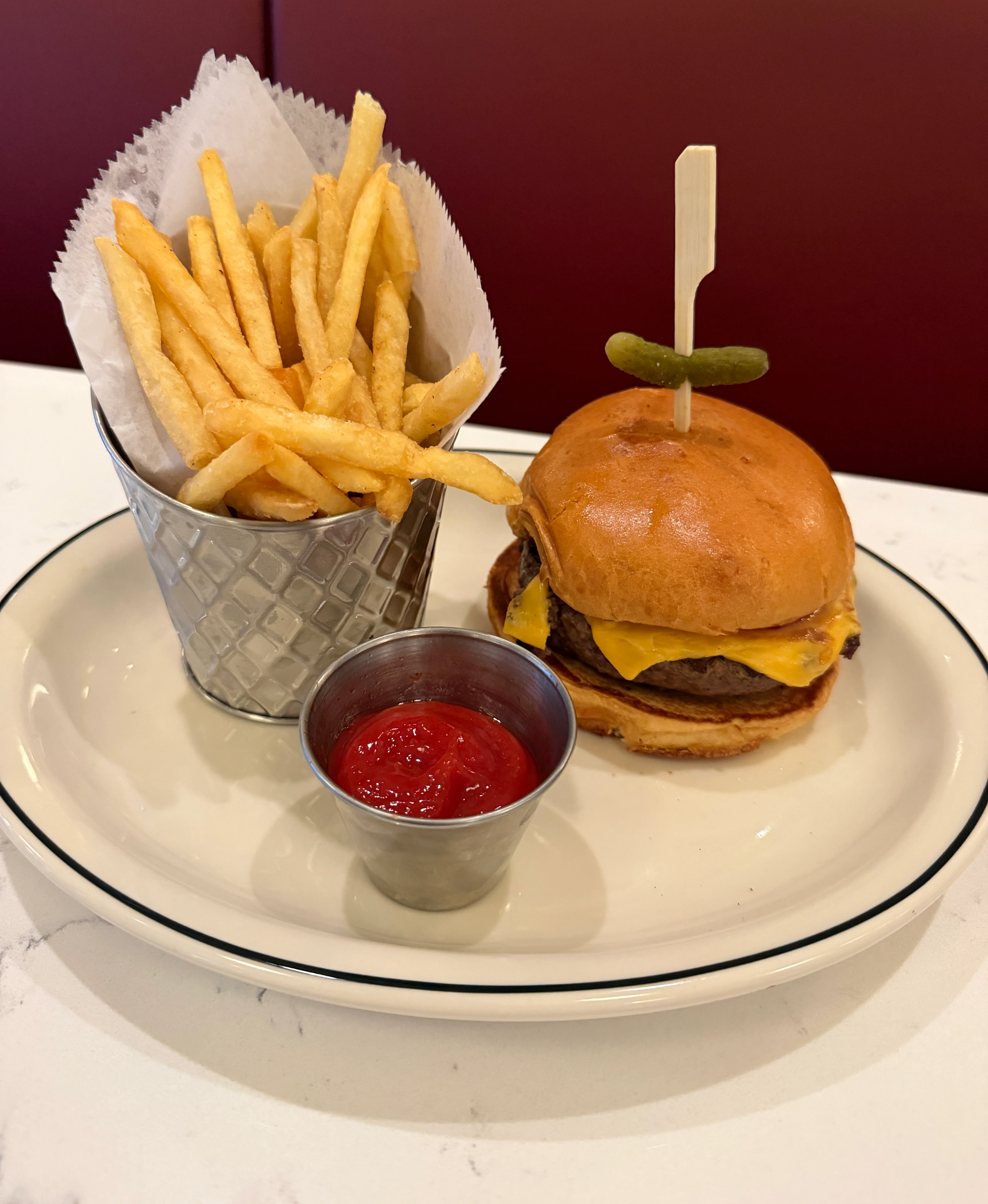 Hamburger plated elegantly and sparsely on a platter.