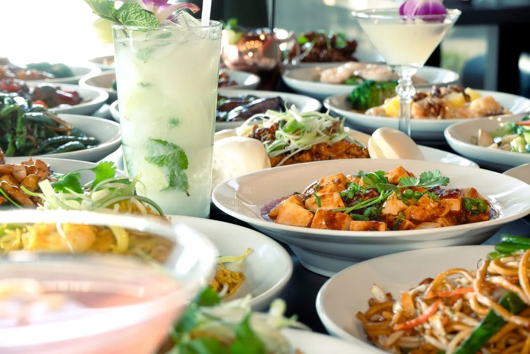Assorted Asian dishes including tofu stir-fry and refreshing cocktails