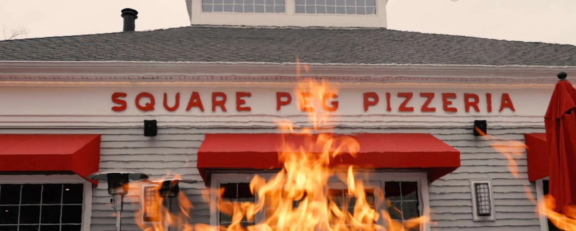 Exterior of Square Peg Pizzeria with vibrant flames