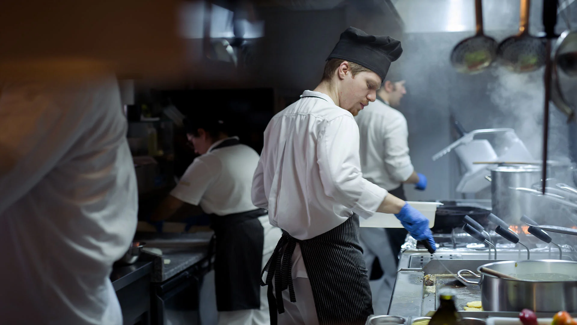 Busy restaurant kitchen with chefs preparing dishes