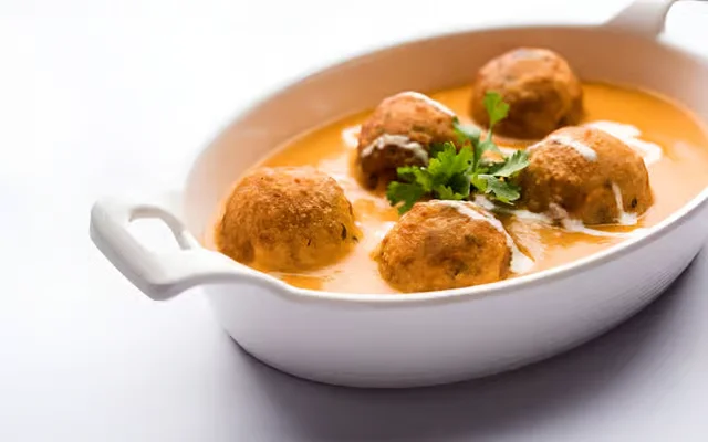 Delicious meatballs in creamy sauce garnished with cilantro.