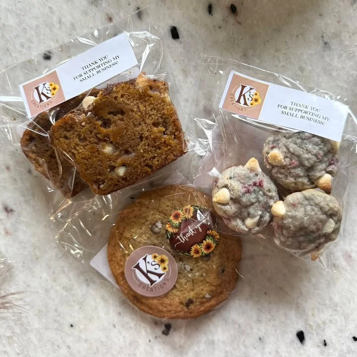 An assortment of baked goods including a slice of loaf, a cookie, and two bite-sized treats, all packaged and labeled.