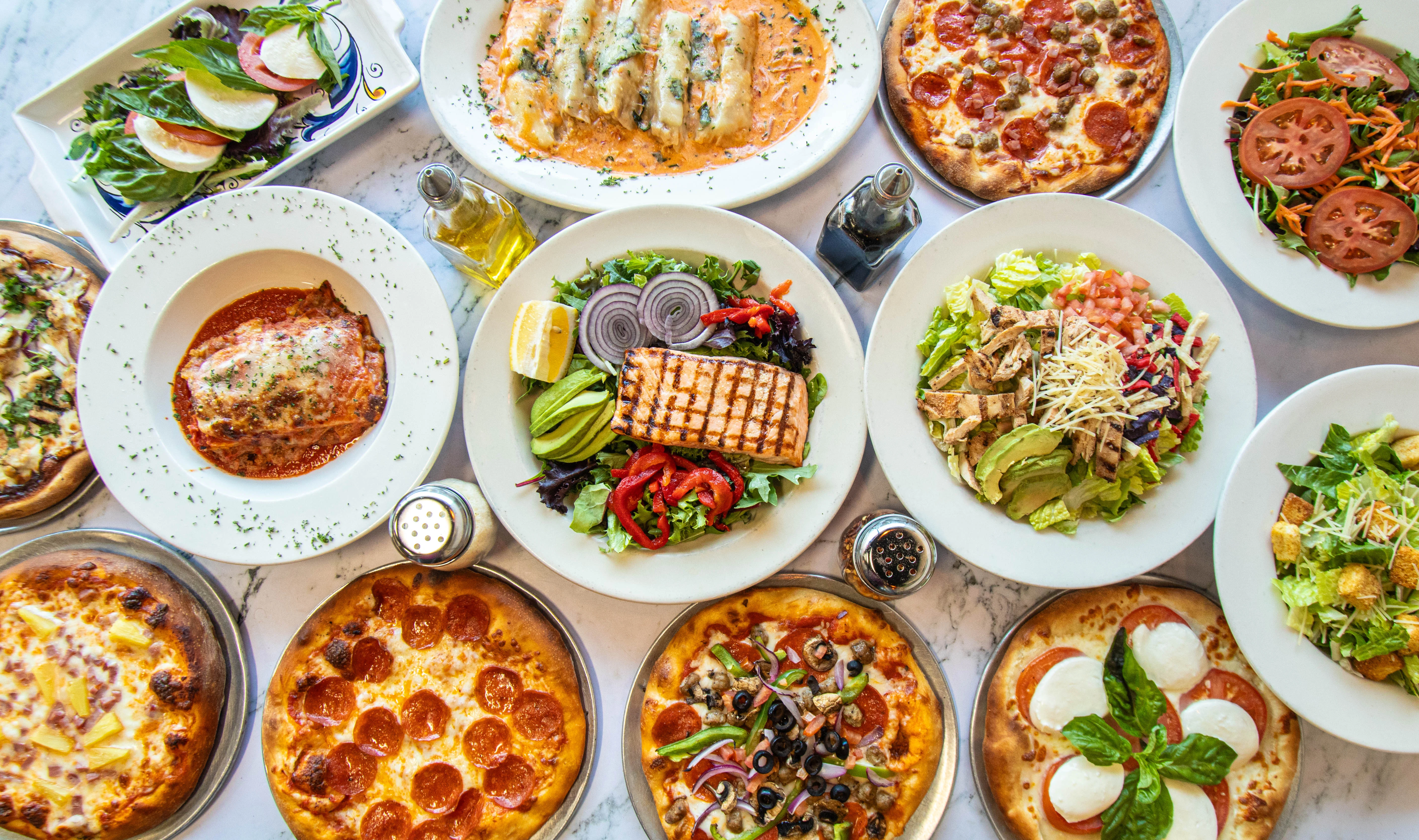 Variety of Italian dishes including pizza and pasta on a dining table
