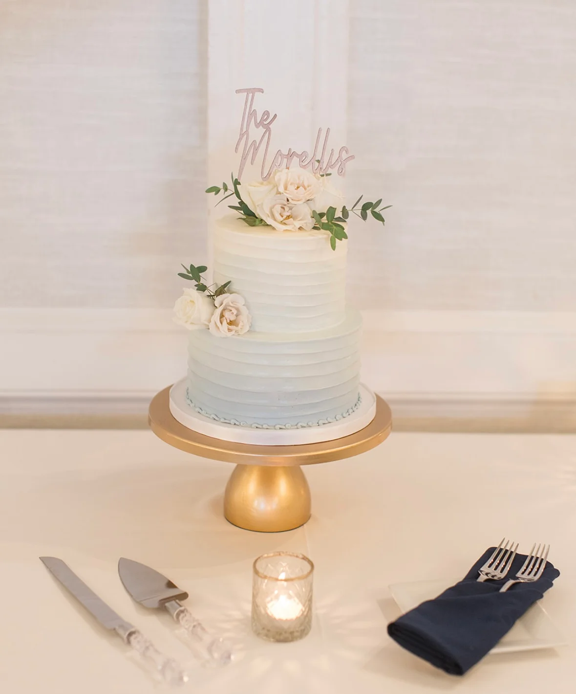 Elegant wedding cake with floral decor and personalized topper