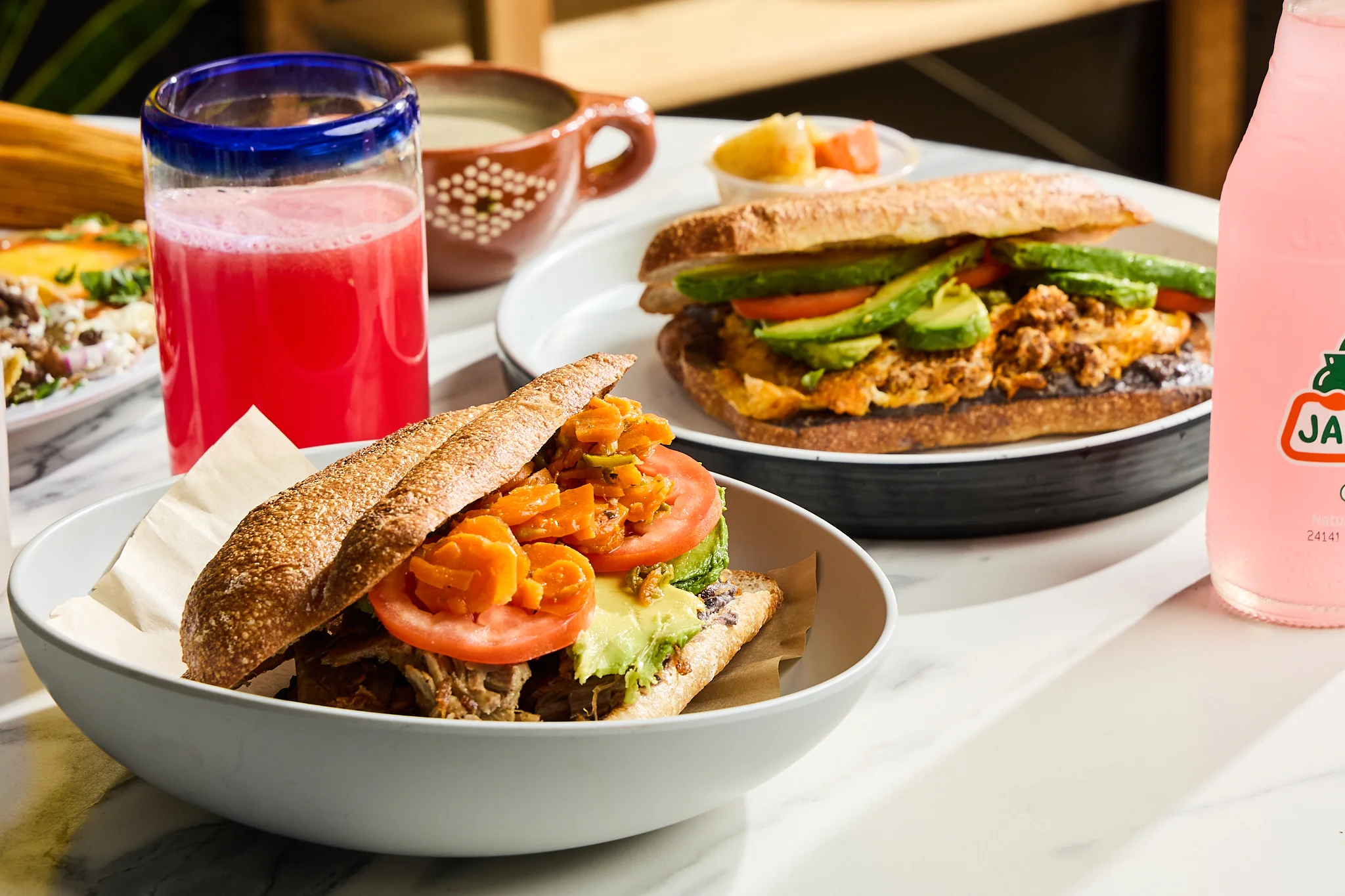 Mexican torta with fresh toppings and beverages