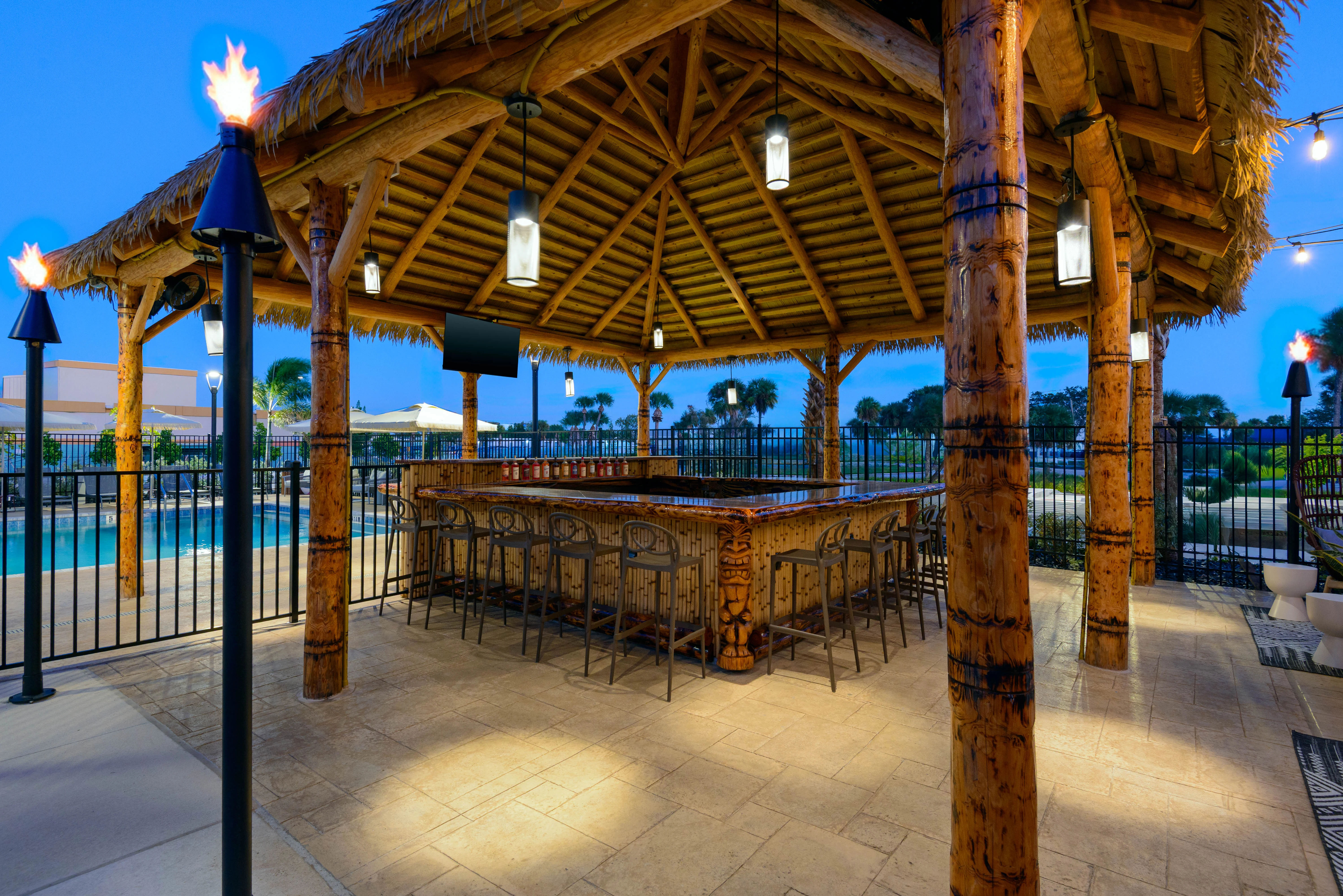 Tropical outdoor bar with tiki decor and poolside seating