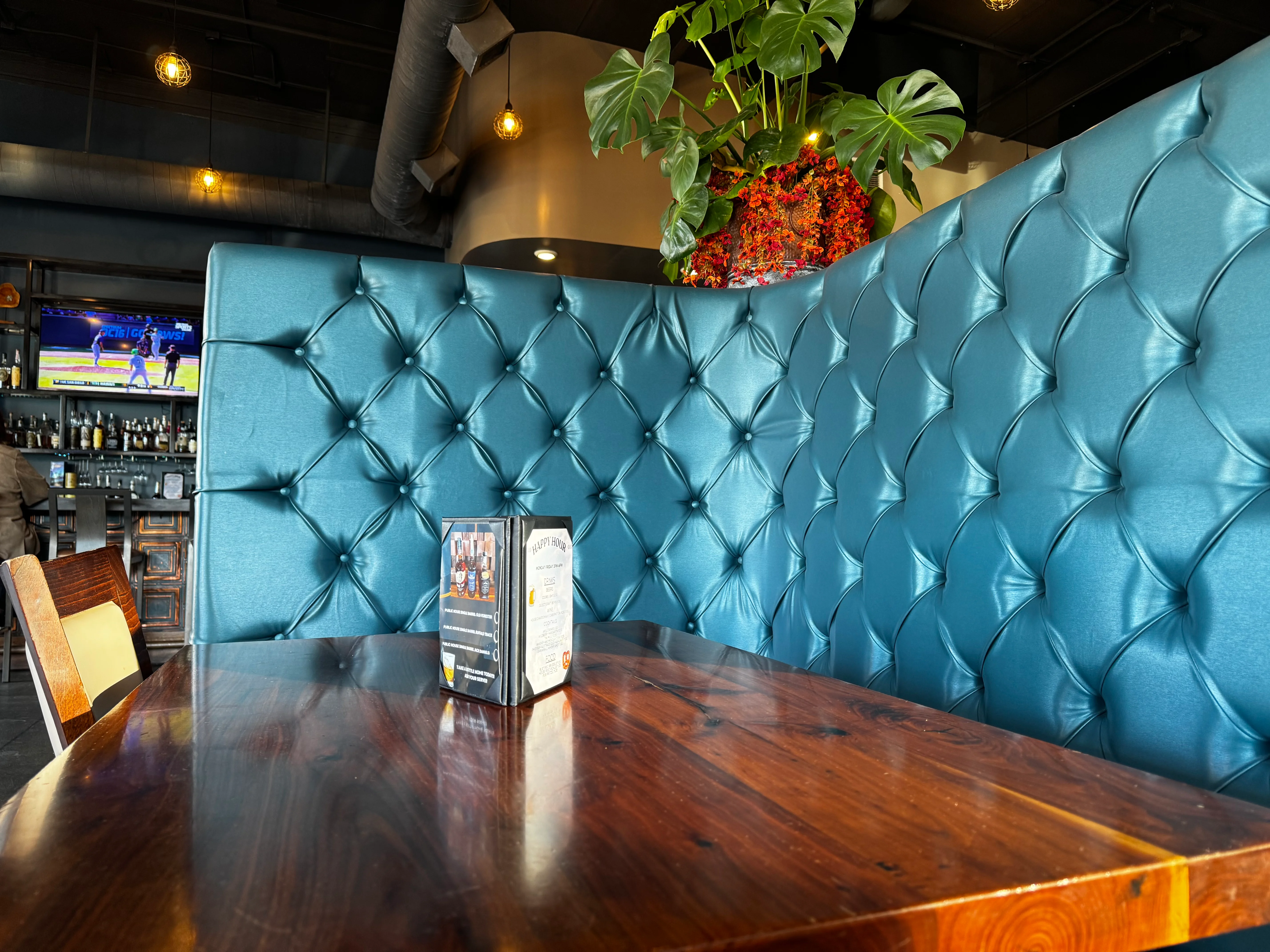 Stylish restaurant booth with teal upholstery and wooden table