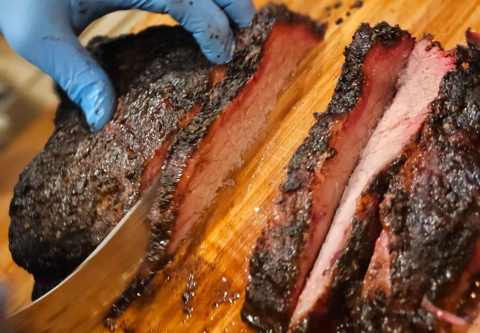 Sliced smoked brisket on a wooden cutting board