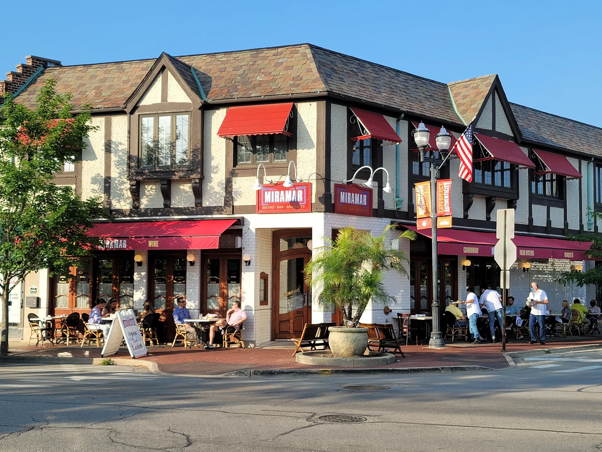Charming bistro exterior with outdoor seating and vibrant awnings