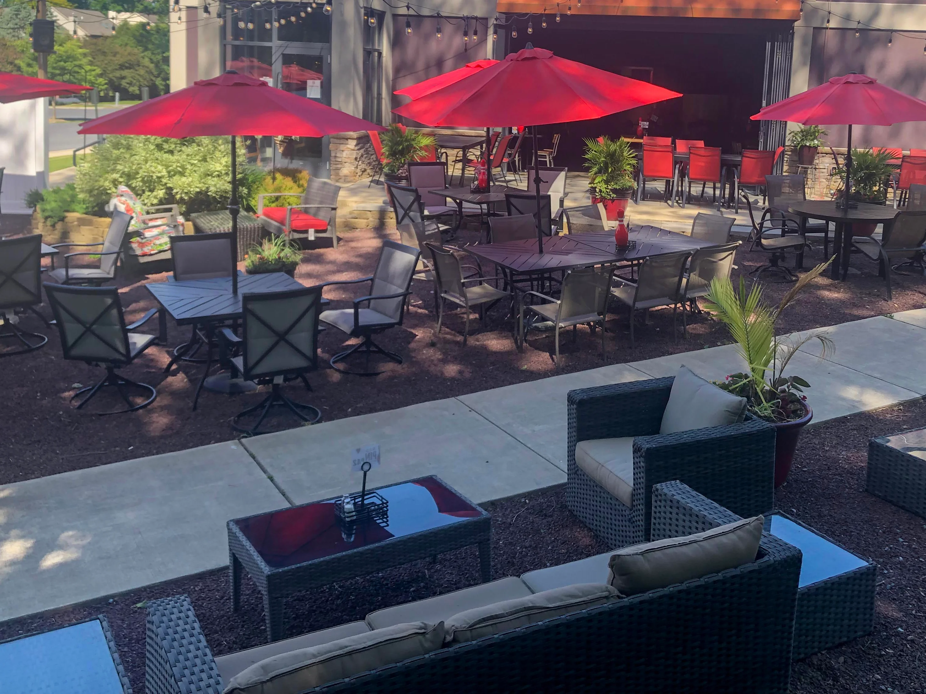 Outdoor dining area with red umbrellas and modern seating