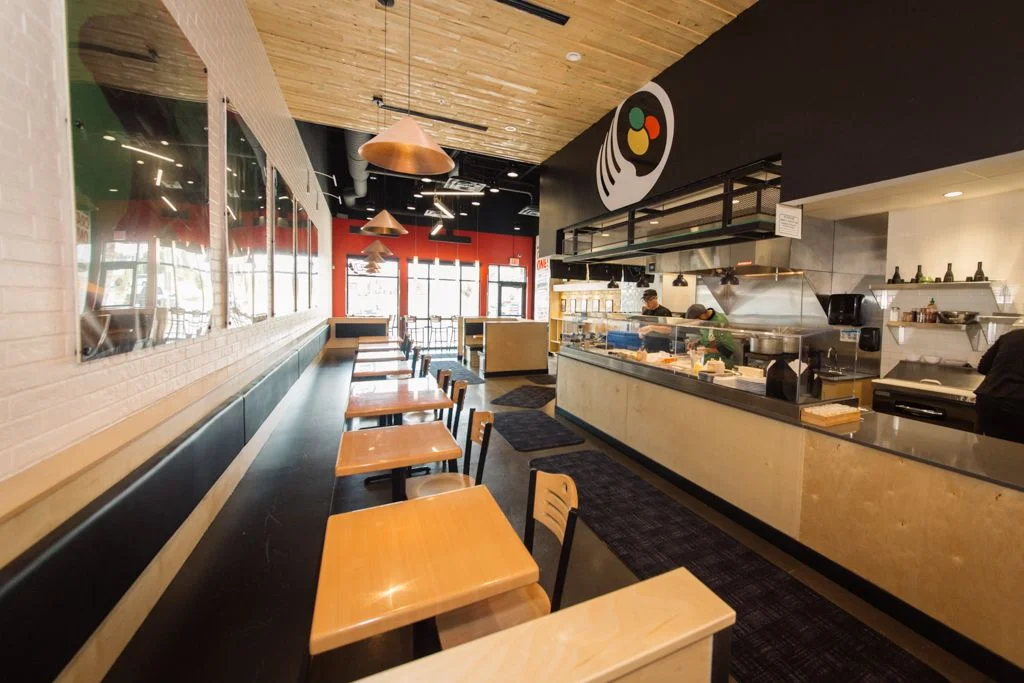 Modern restaurant interior with wooden accents and open kitchen