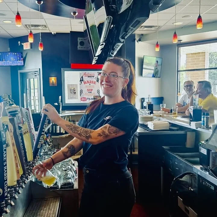 Bartender serving craft beer at a lively bar