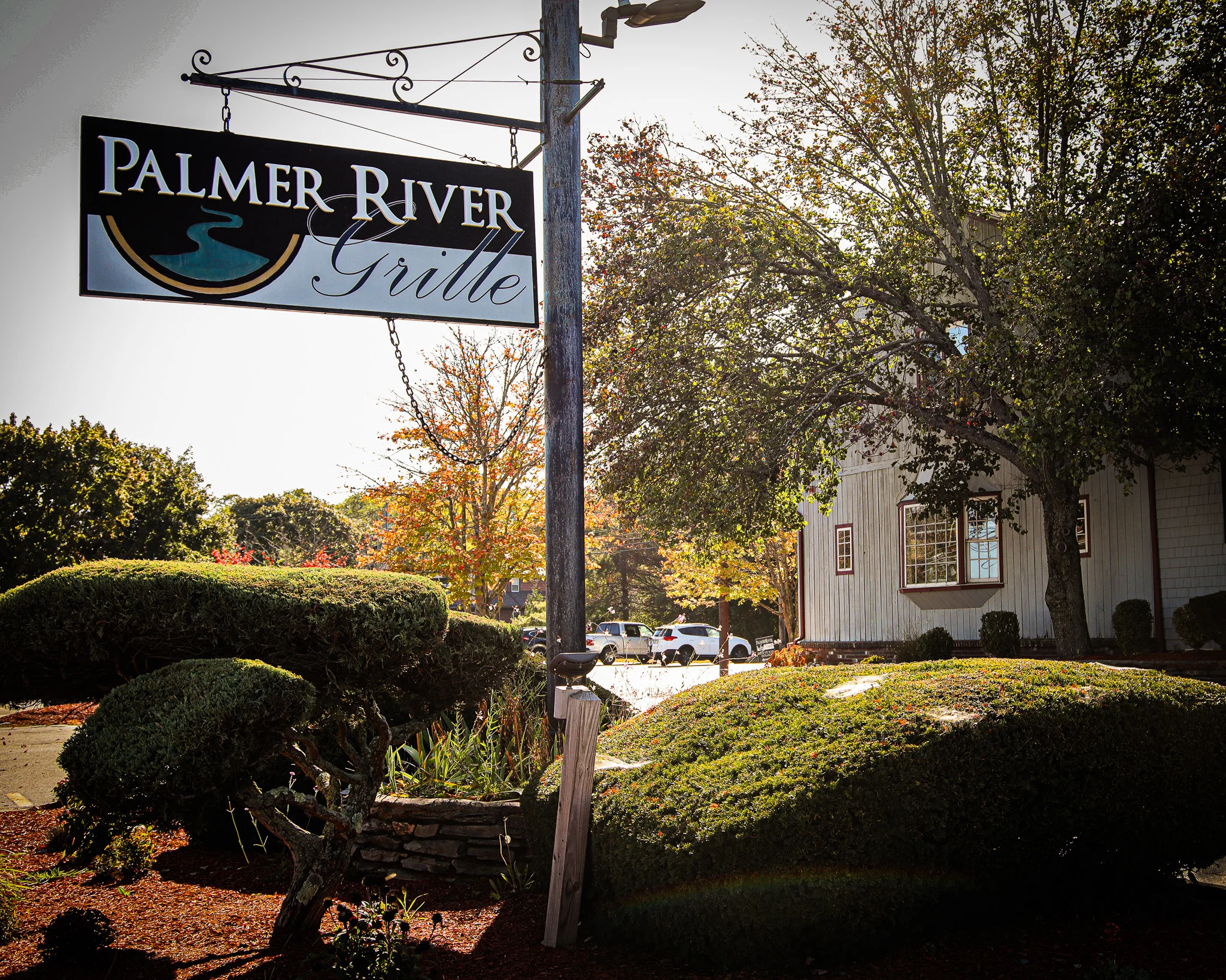 Sign for Palmer River Grille restaurant with autumn foliage