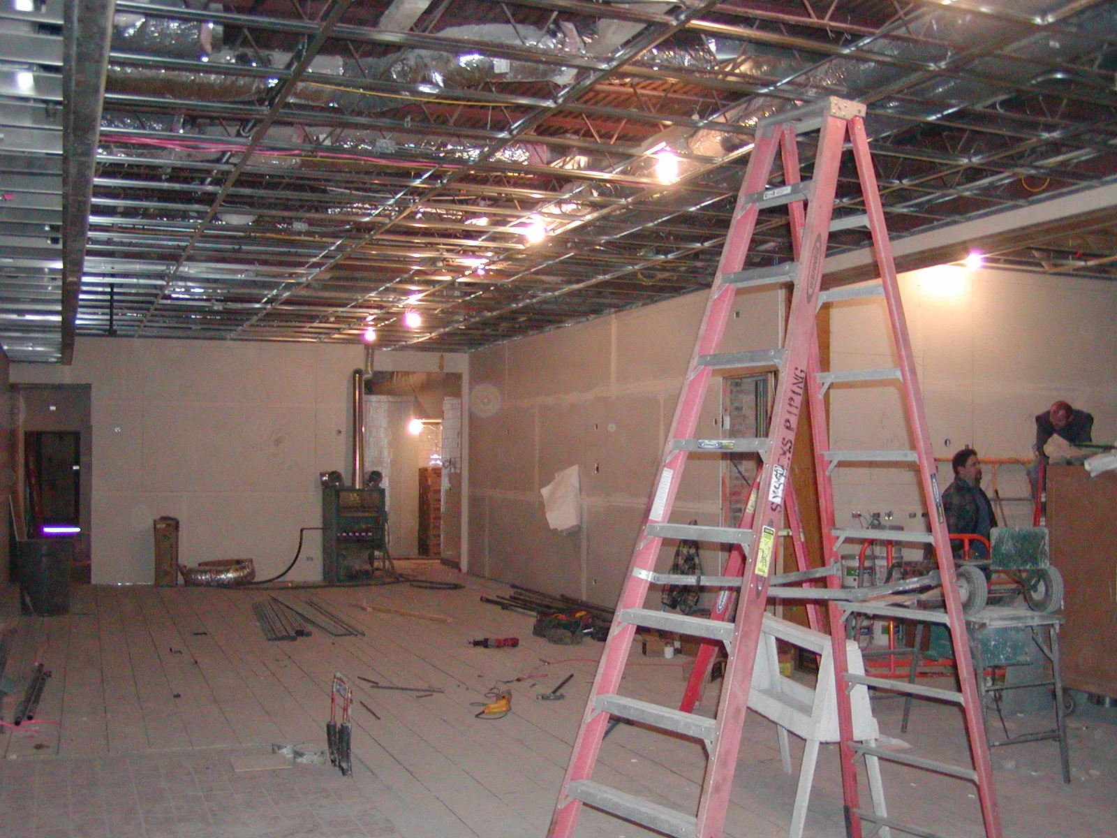 Construction site with ladders and exposed ceiling framework