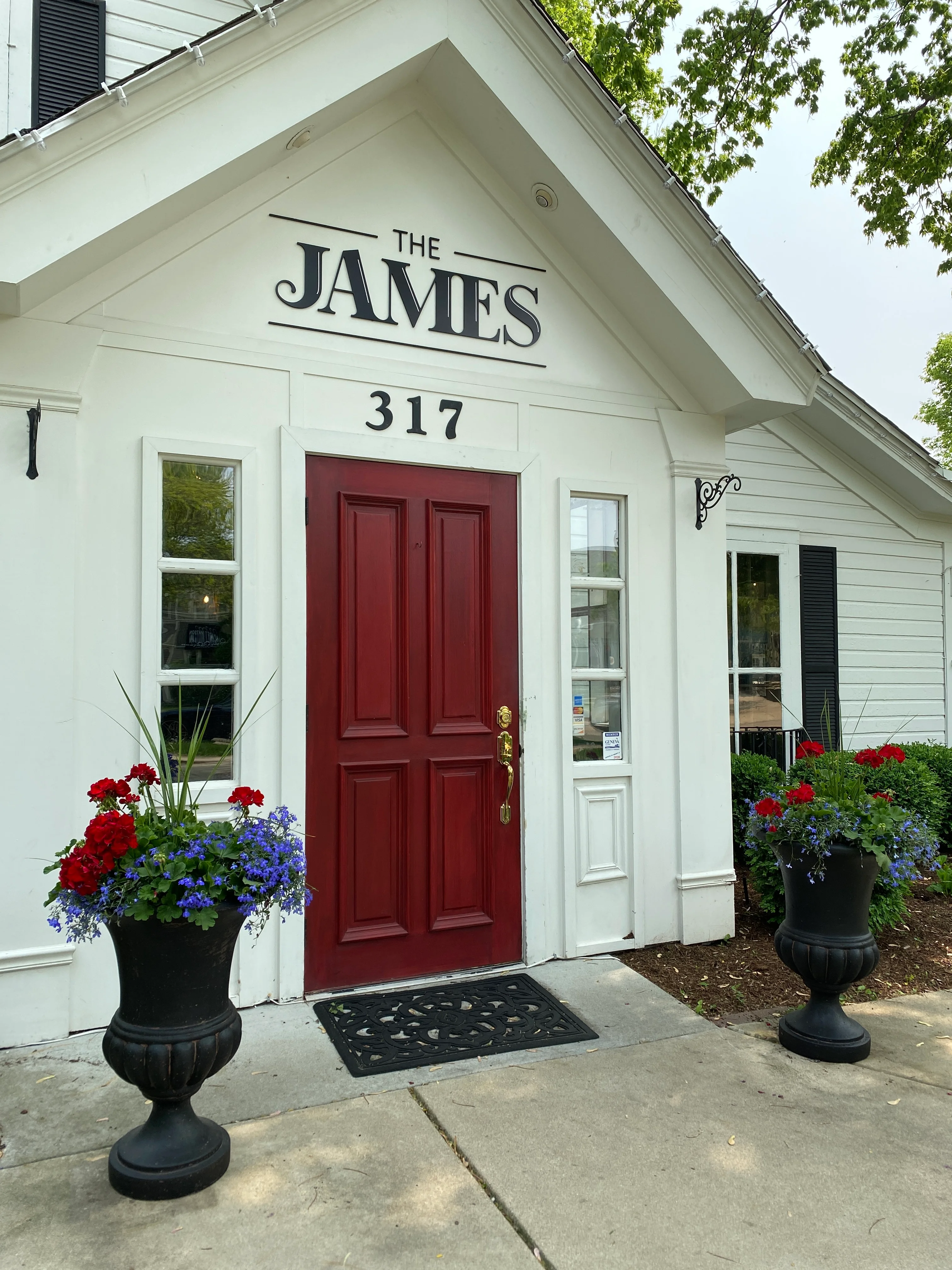 Charming restaurant entrance with red door and flower pots