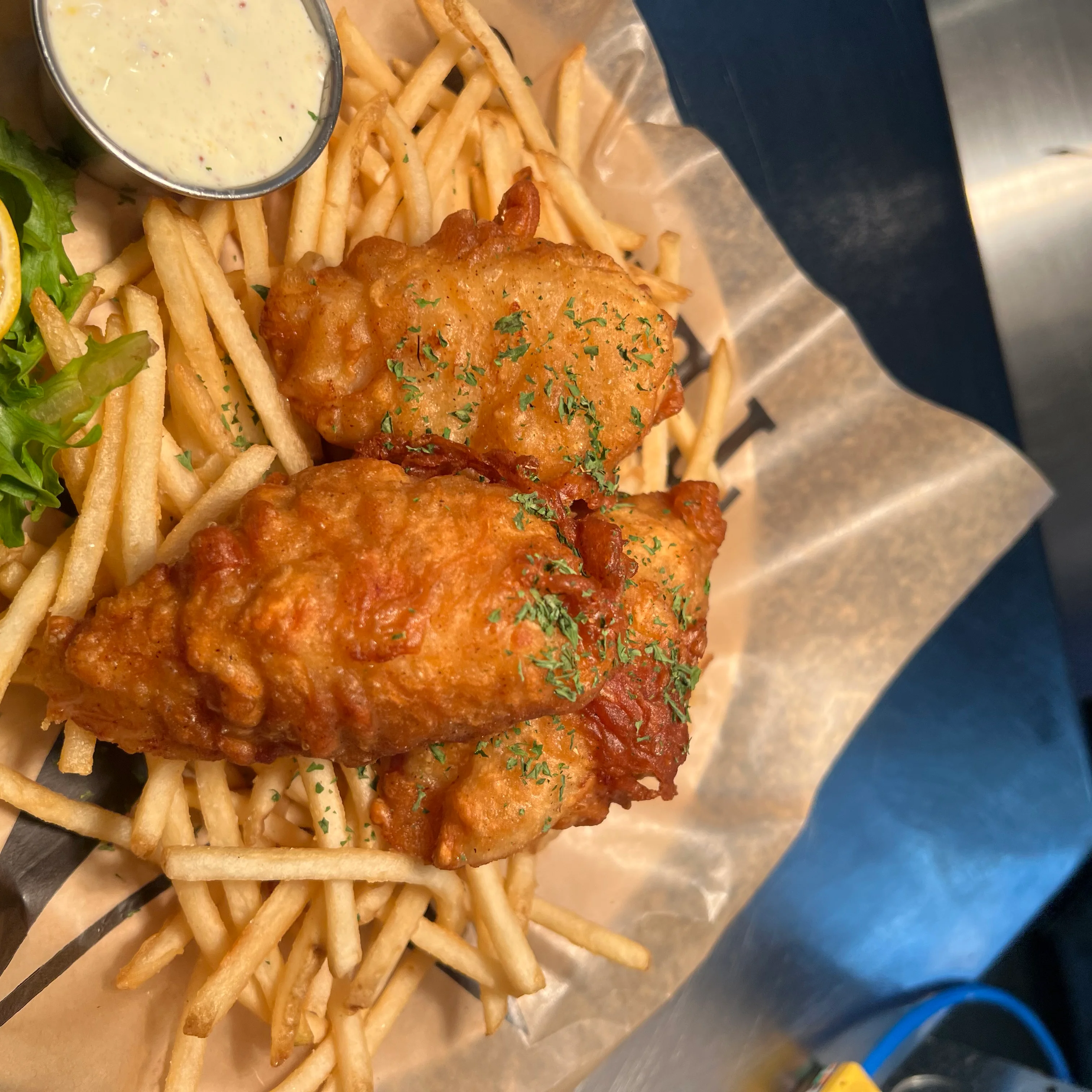 Crispy fish and chips served with fries and lemon
