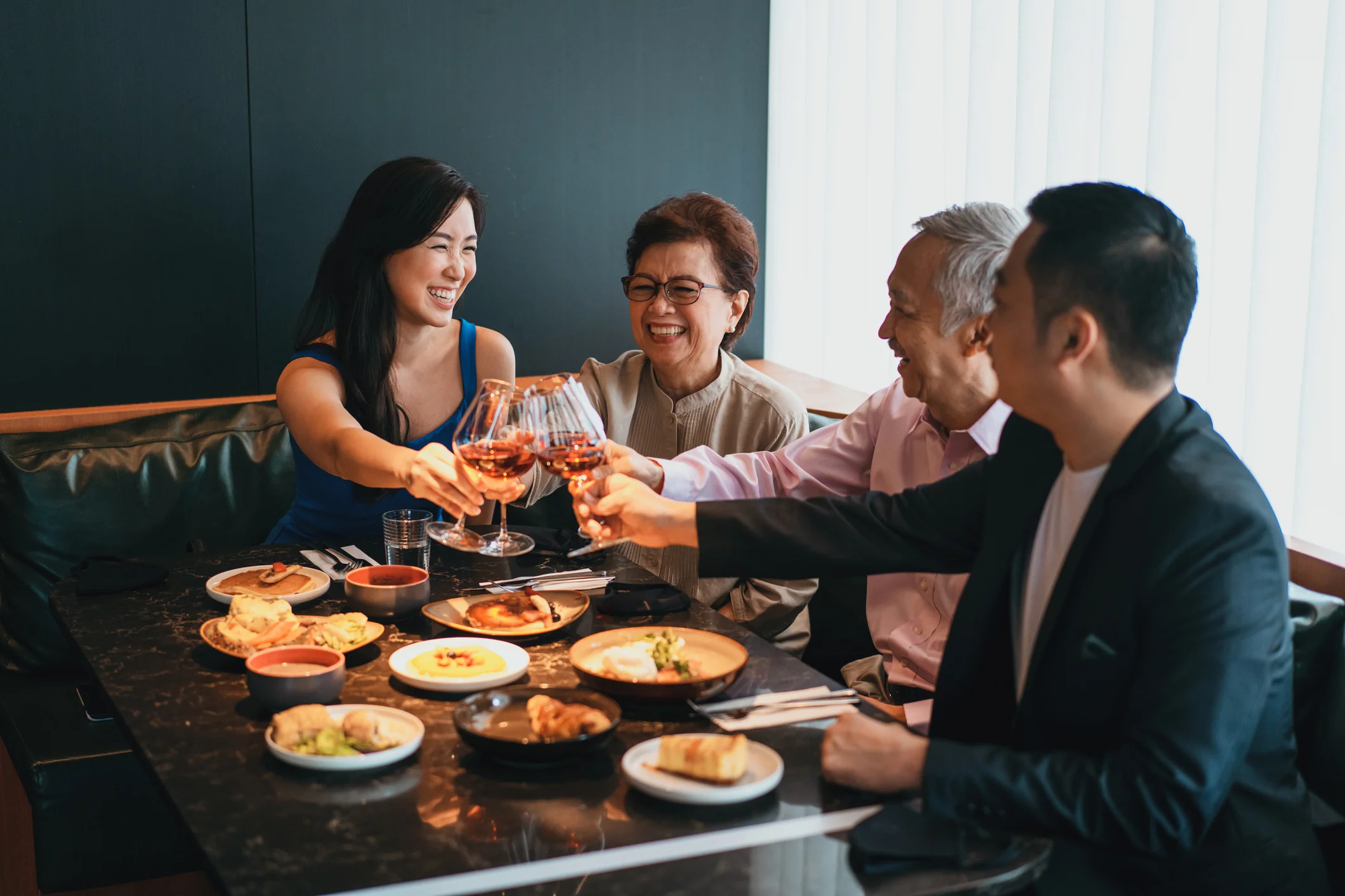 Group toasting with glasses in a modern restaurant setting