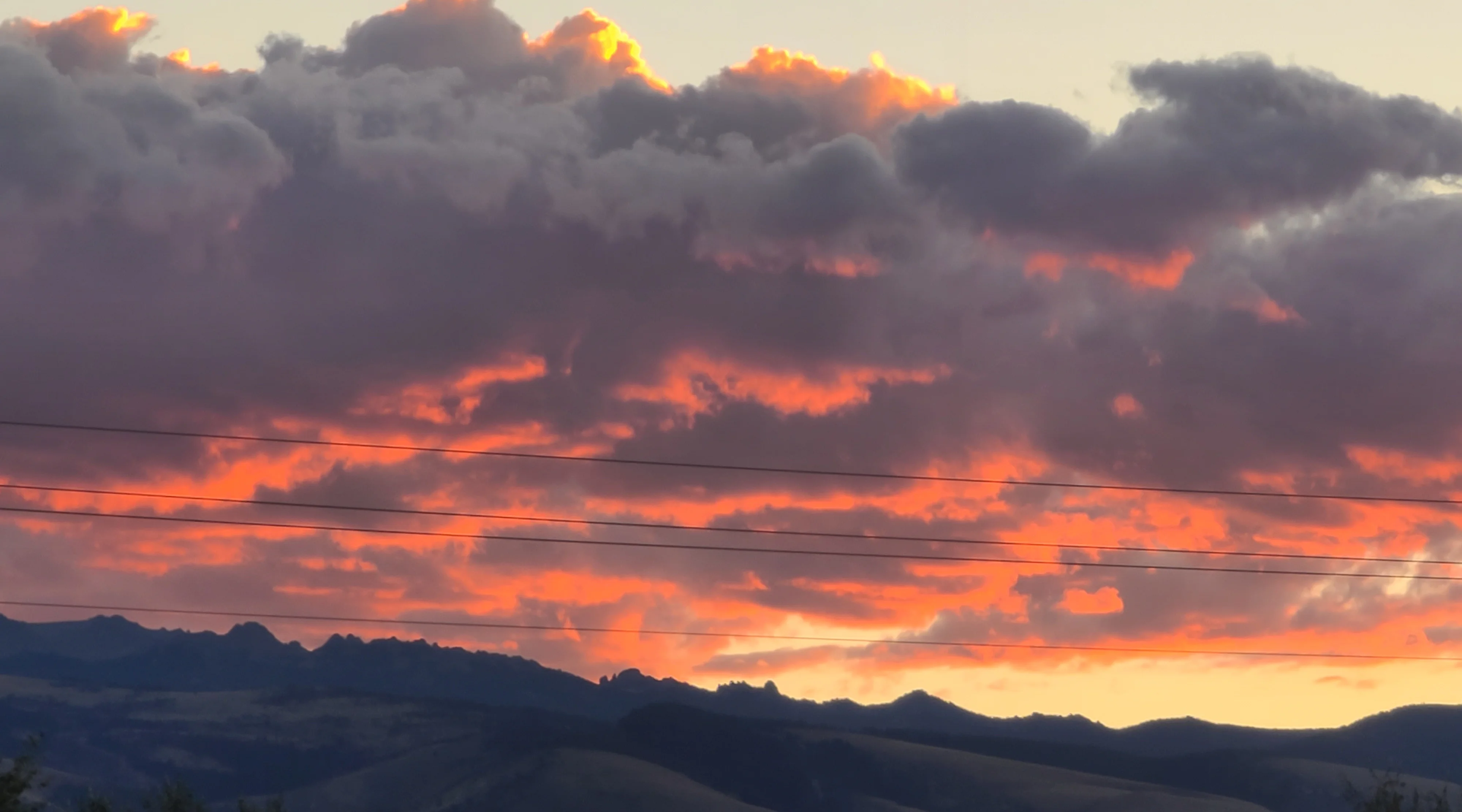 Vibrant sunset over mountain range with dramatic clouds