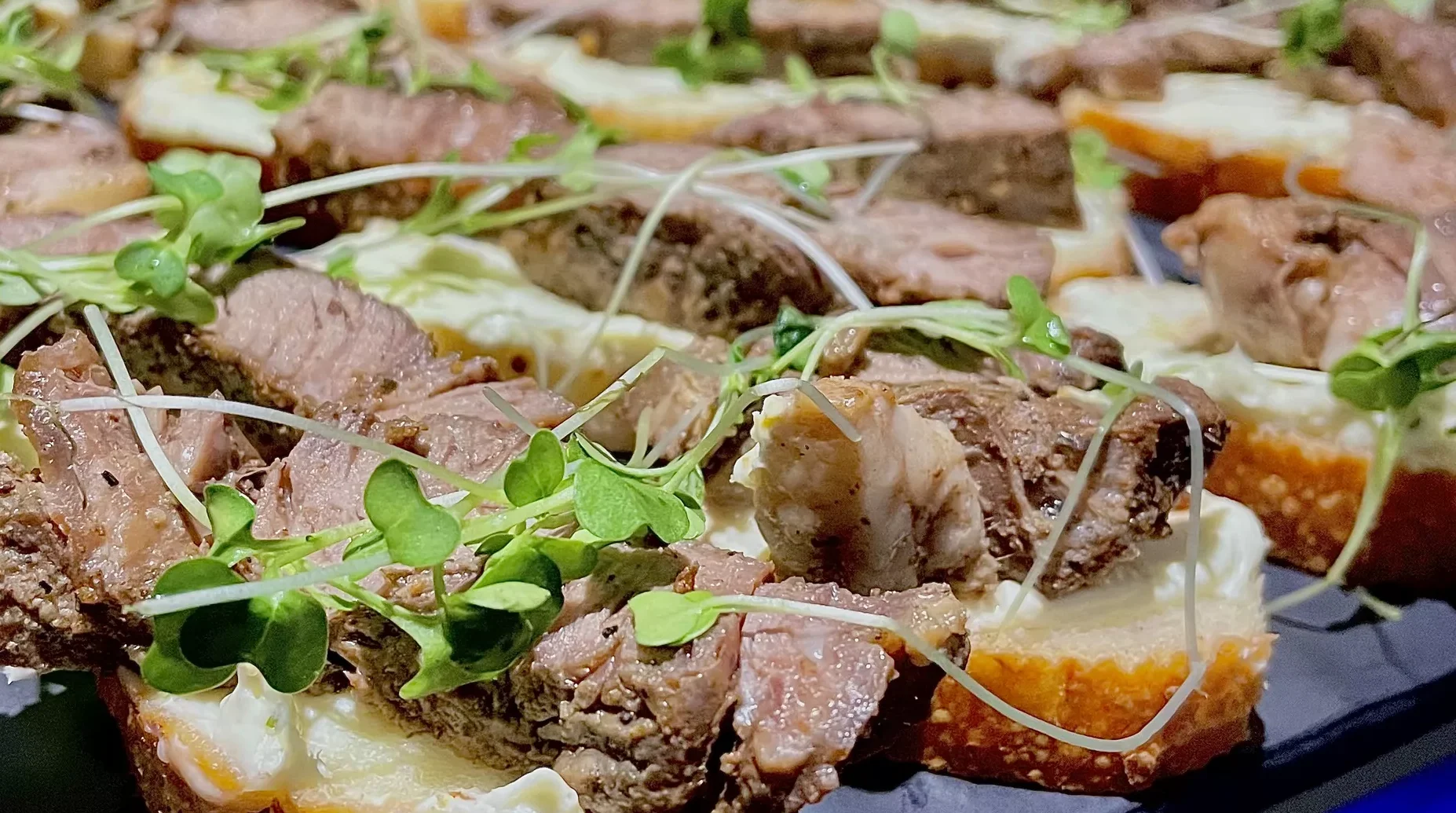 Brisket Sliders topped with arugula