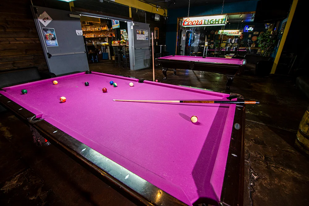 Vibrant purple pool table in a lively bar setting