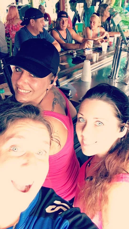 Friends enjoying drinks at a lively bar with a tropical vibe