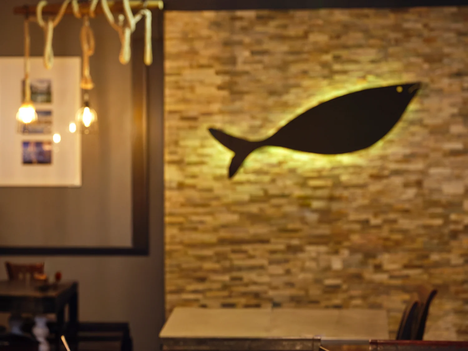 Cozy restaurant interior with stone wall and fish decor