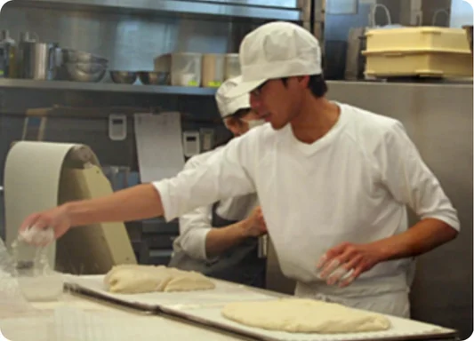 Baker shaping dough in a professional kitchen