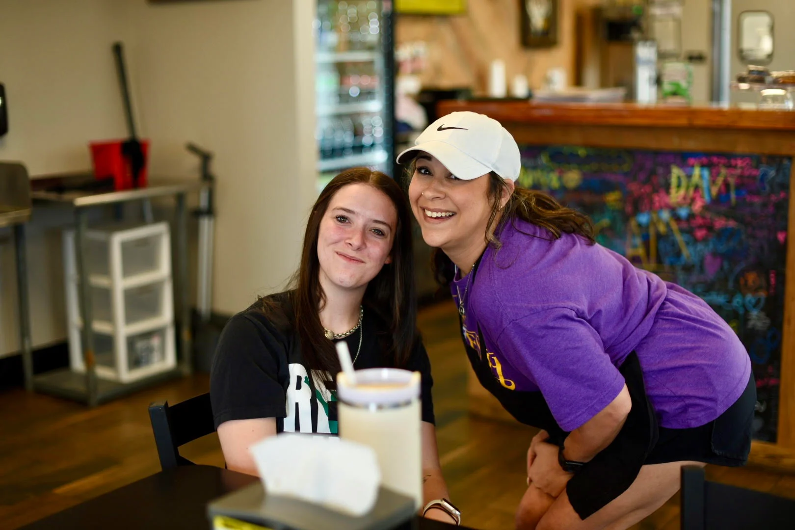 Two smiling women in a cozy restaurant setting