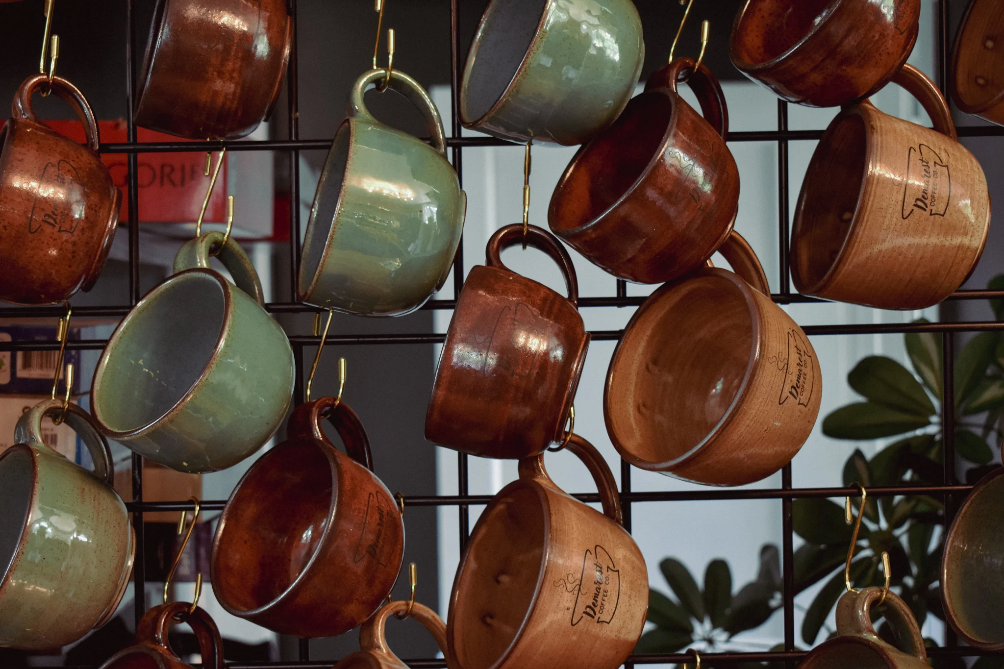 Colorful ceramic mugs hanging in a cozy cafe
