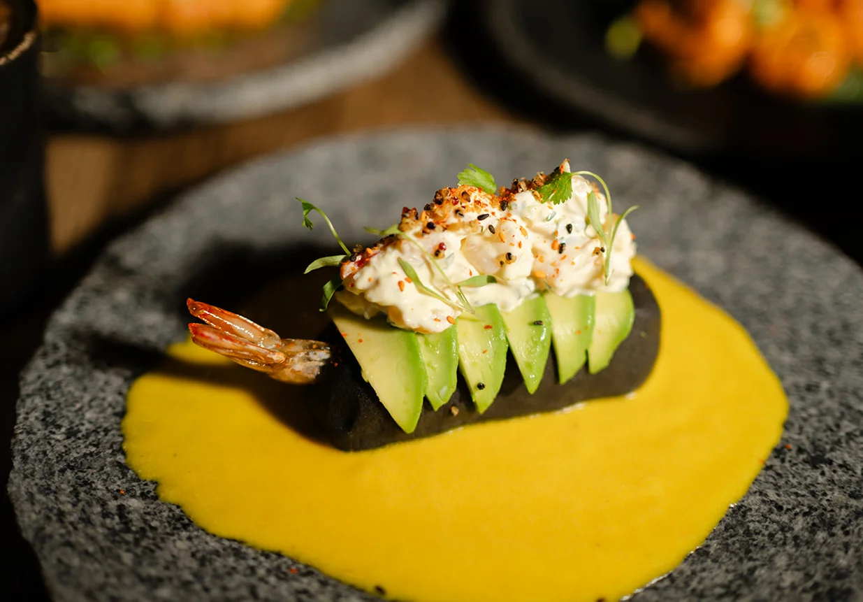 Gourmet shrimp ceviche on black tortilla with mango sauce