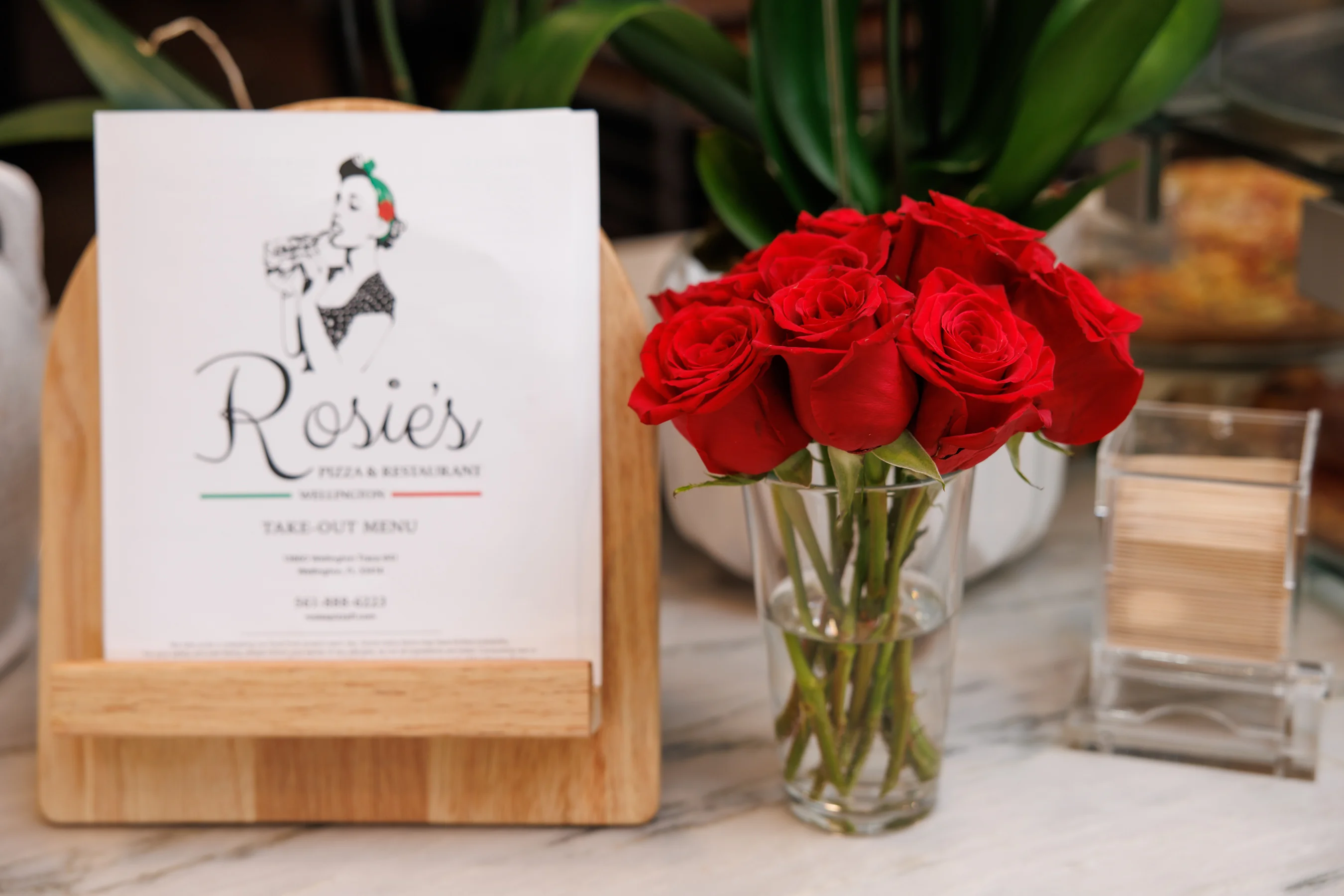 An image of a bouquet of roses positioned next to Rosie's takeout menu.