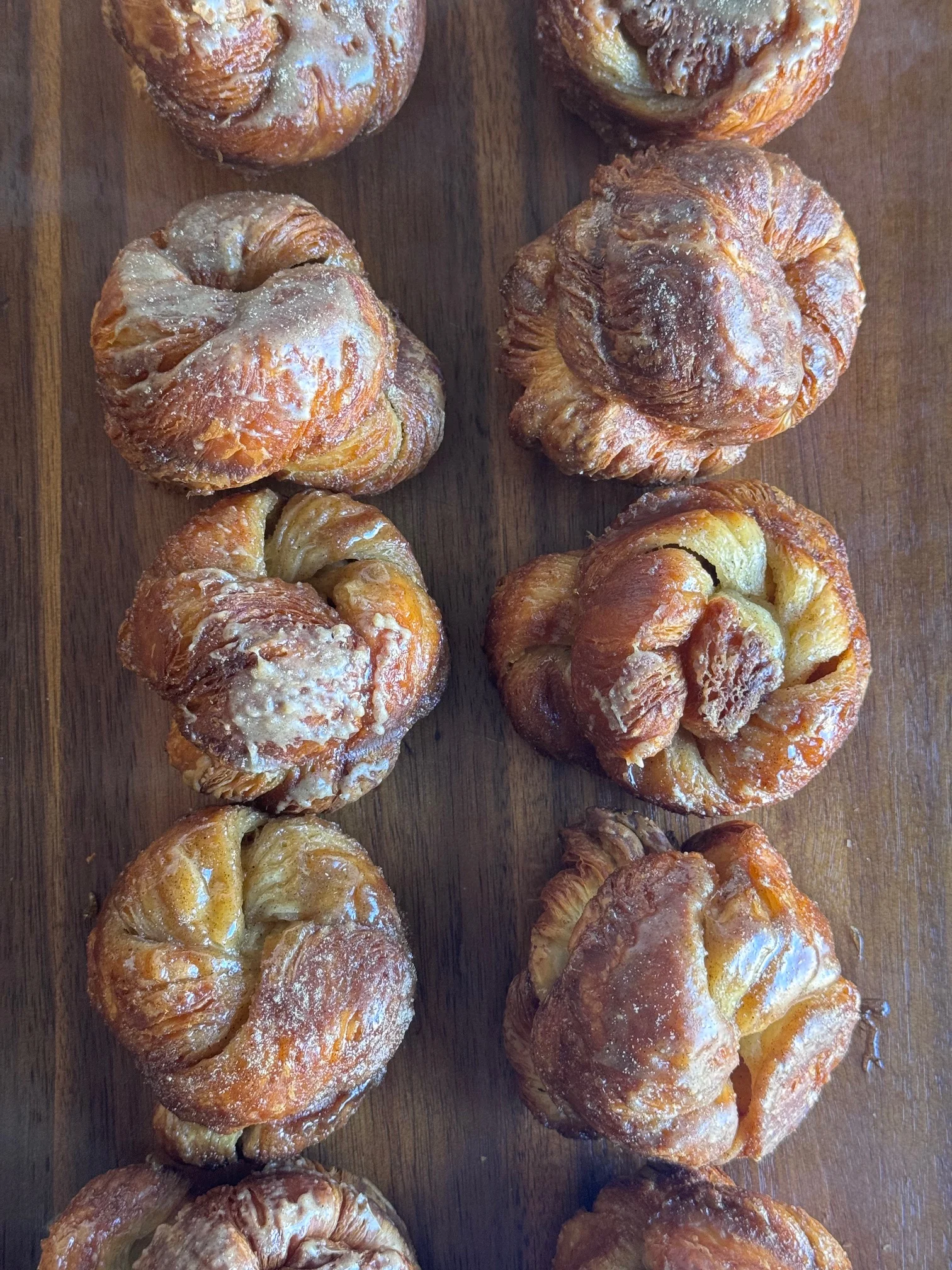 Freshly baked French kouign-amann pastries on a wooden board
