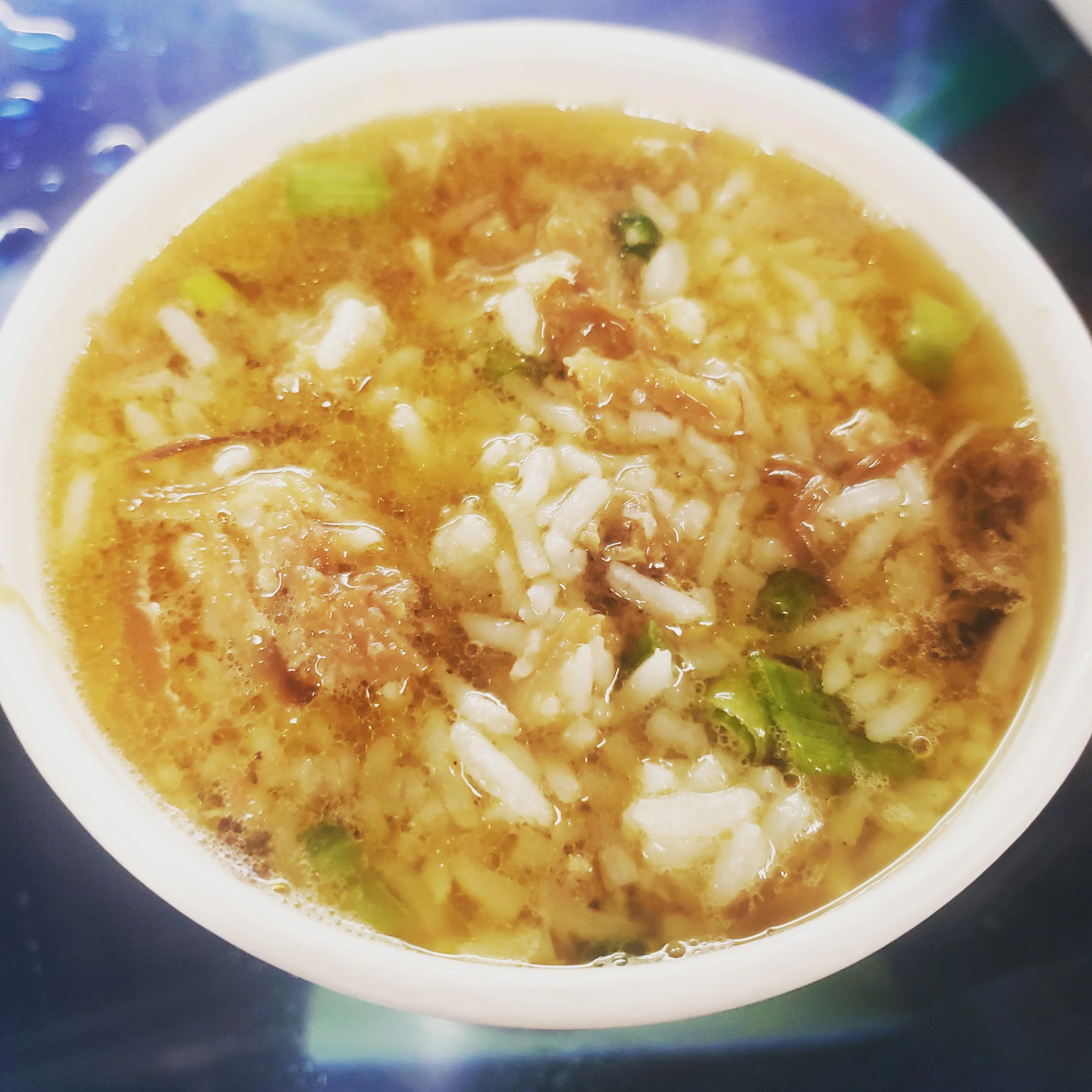 Savory bowl of Chinese congee with scallions and meat