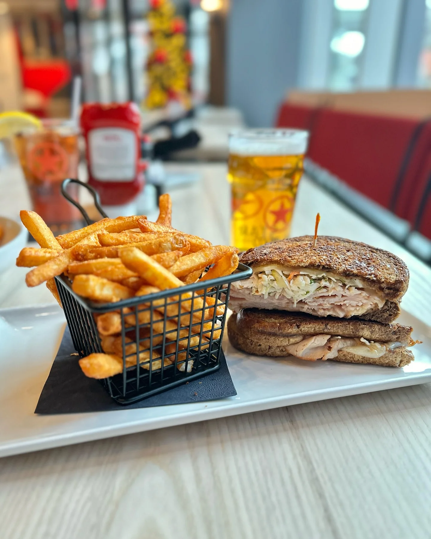 Grilled turkey sandwich with fries in a modern restaurant