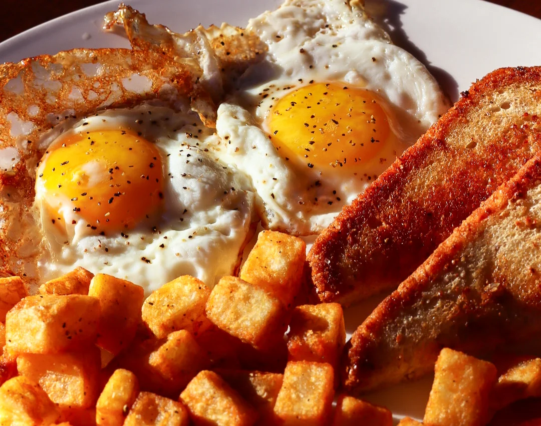 Classic American breakfast with eggs, toast, and crispy potatoes