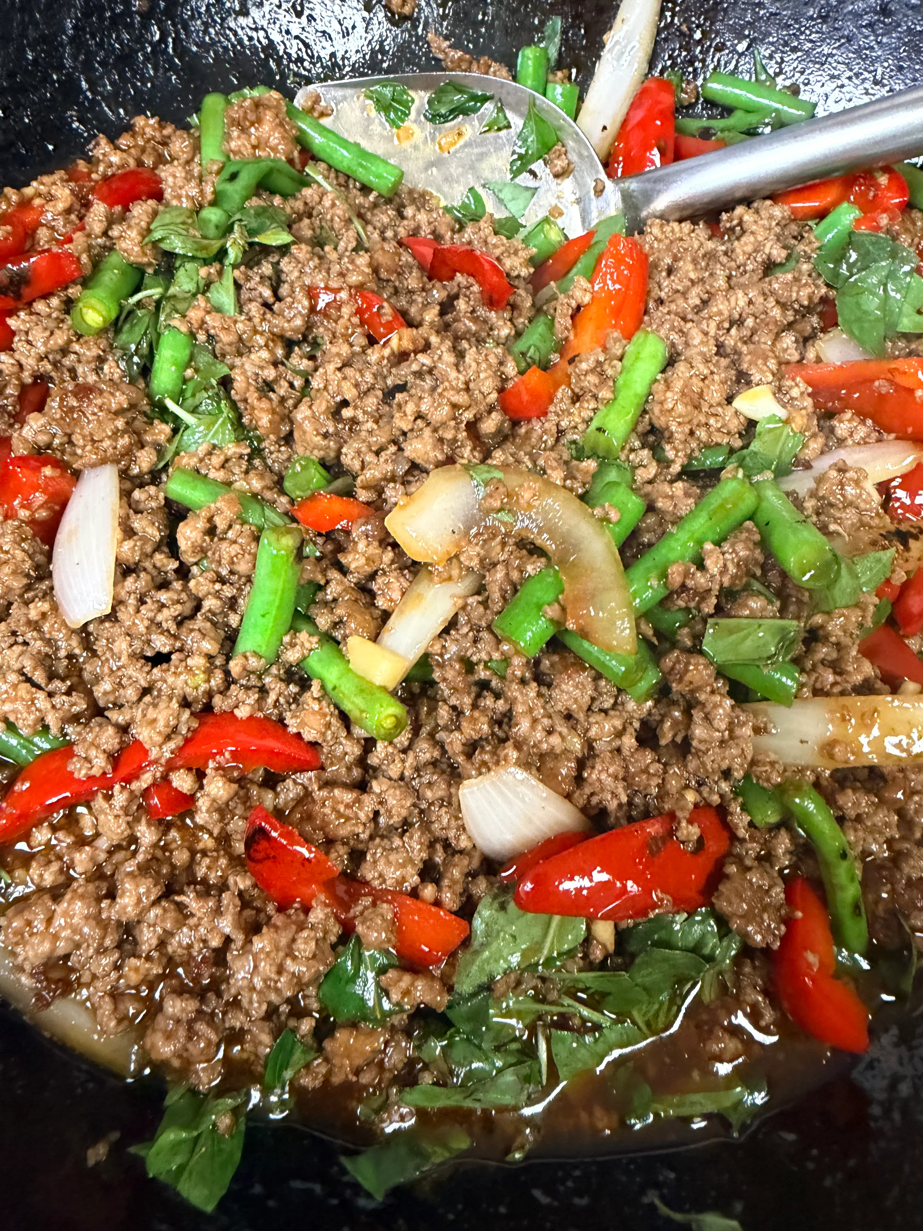 Thai basil beef stir-fry with vibrant vegetables in a wok