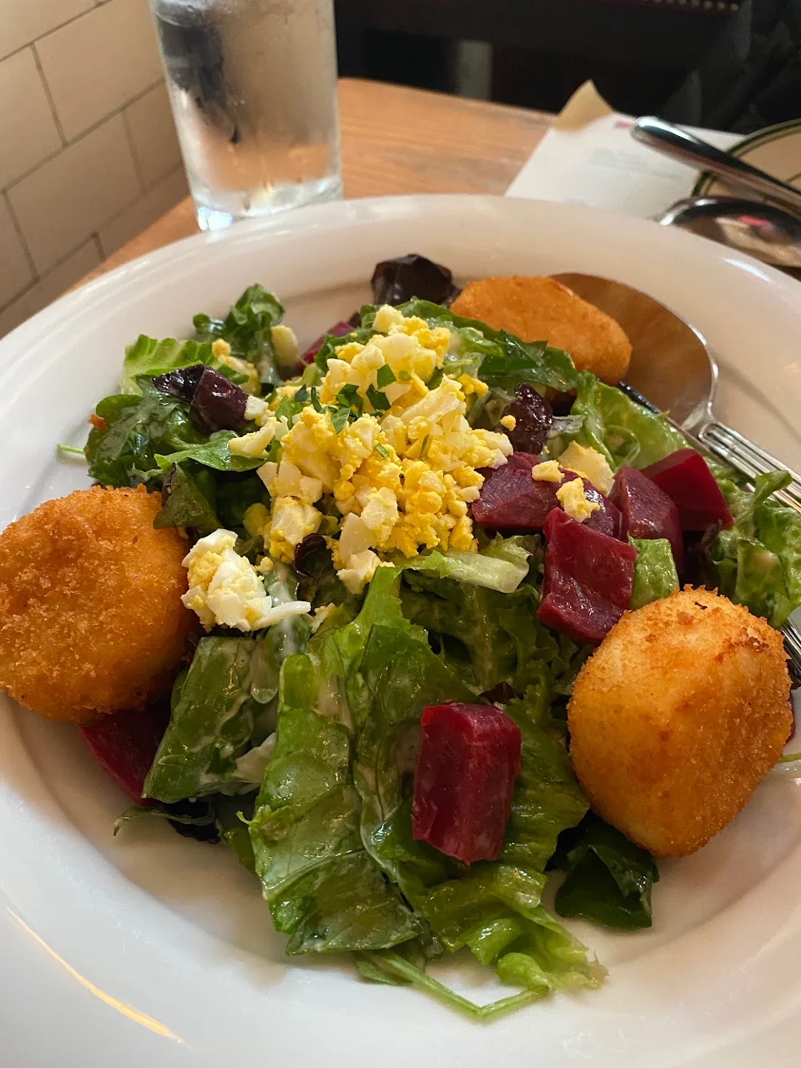 Fresh garden salad with crispy croquettes and boiled egg