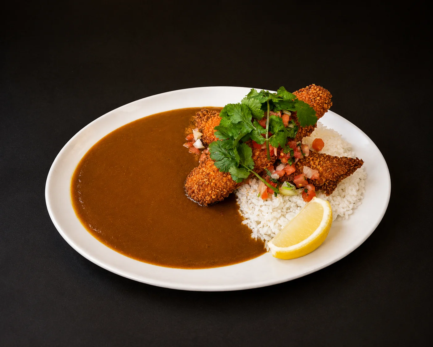 A plate of Japanese fish katsu curry served with breaded fried fish, white rice, curry sauce, fresh pico de gallo, cilantro, and a lemon wedge.