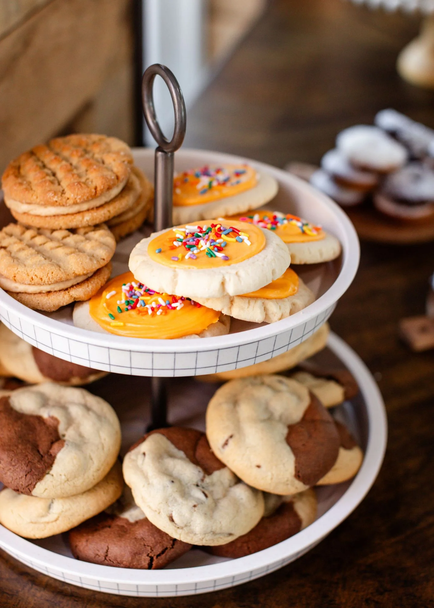 Assorted cookies on a tiered stand, including frosted sugar cookies