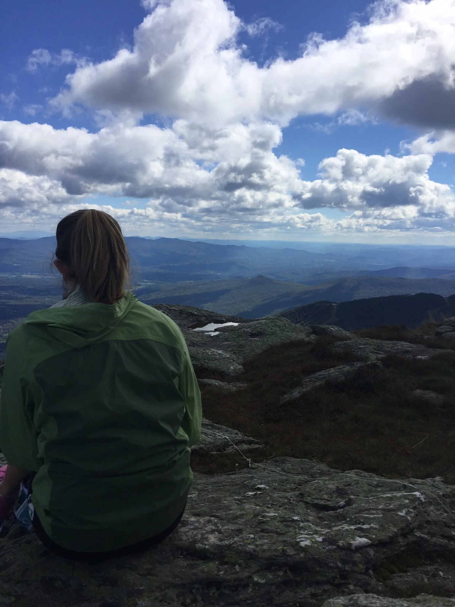 Person enjoying a scenic mountain view under a cloudy sky