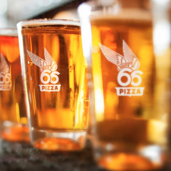 Chilled craft beer in branded glasses at a pizzeria