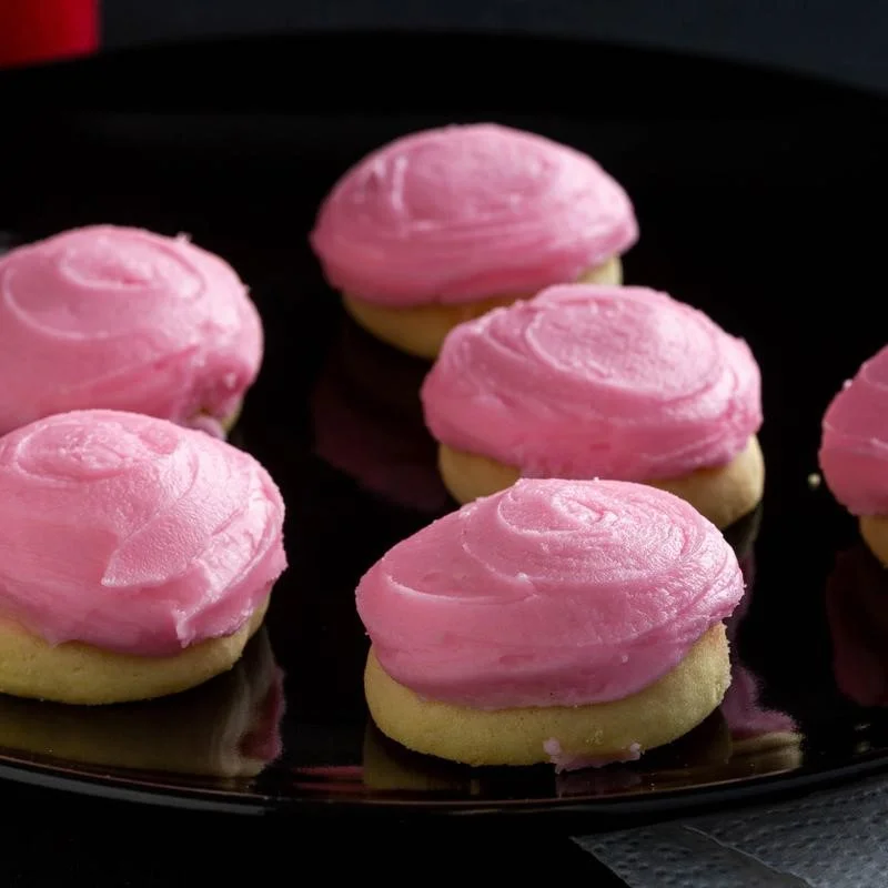 Colorful frosted sugar cookies on a black plate