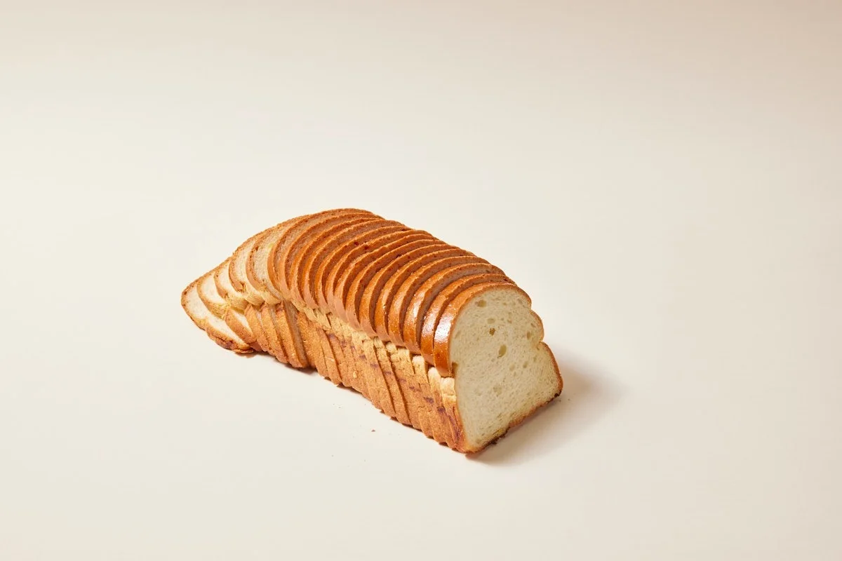 Sliced white sandwich bread on a neutral background