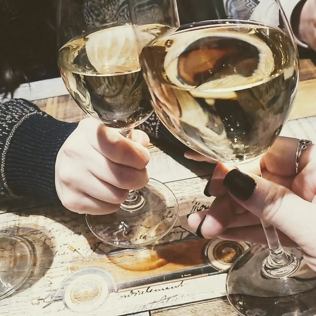 Cheers with wine glasses in a cozy restaurant setting
