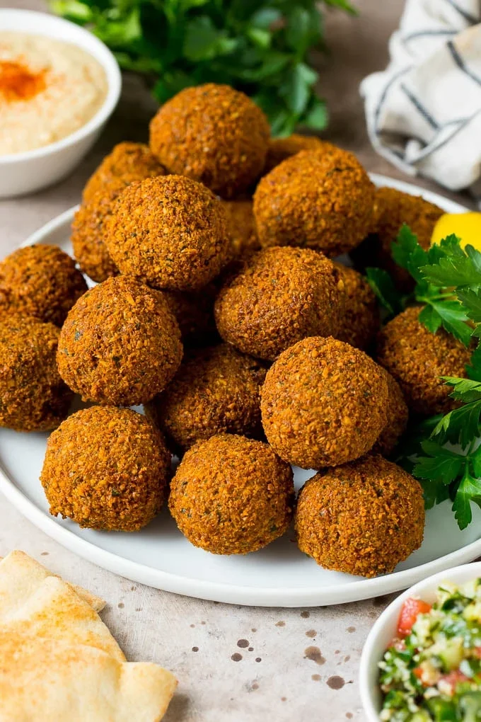 Plate of crispy falafel balls served with fresh herbs