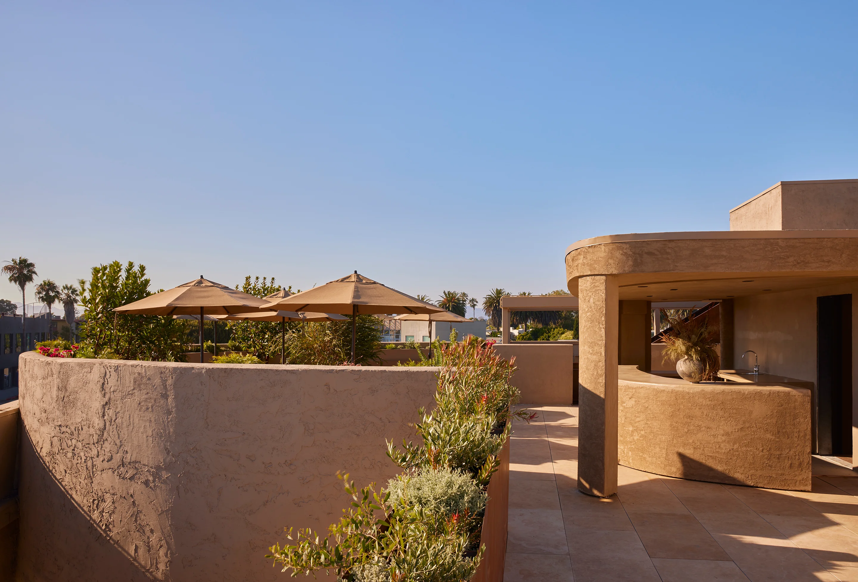 Stylish rooftop terrace with umbrellas and greenery