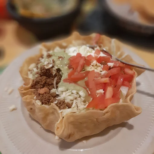 Mexican taco salad served in a crispy tortilla bowl