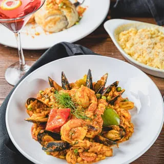Seafood paella with shrimp and mussels in a white bowl