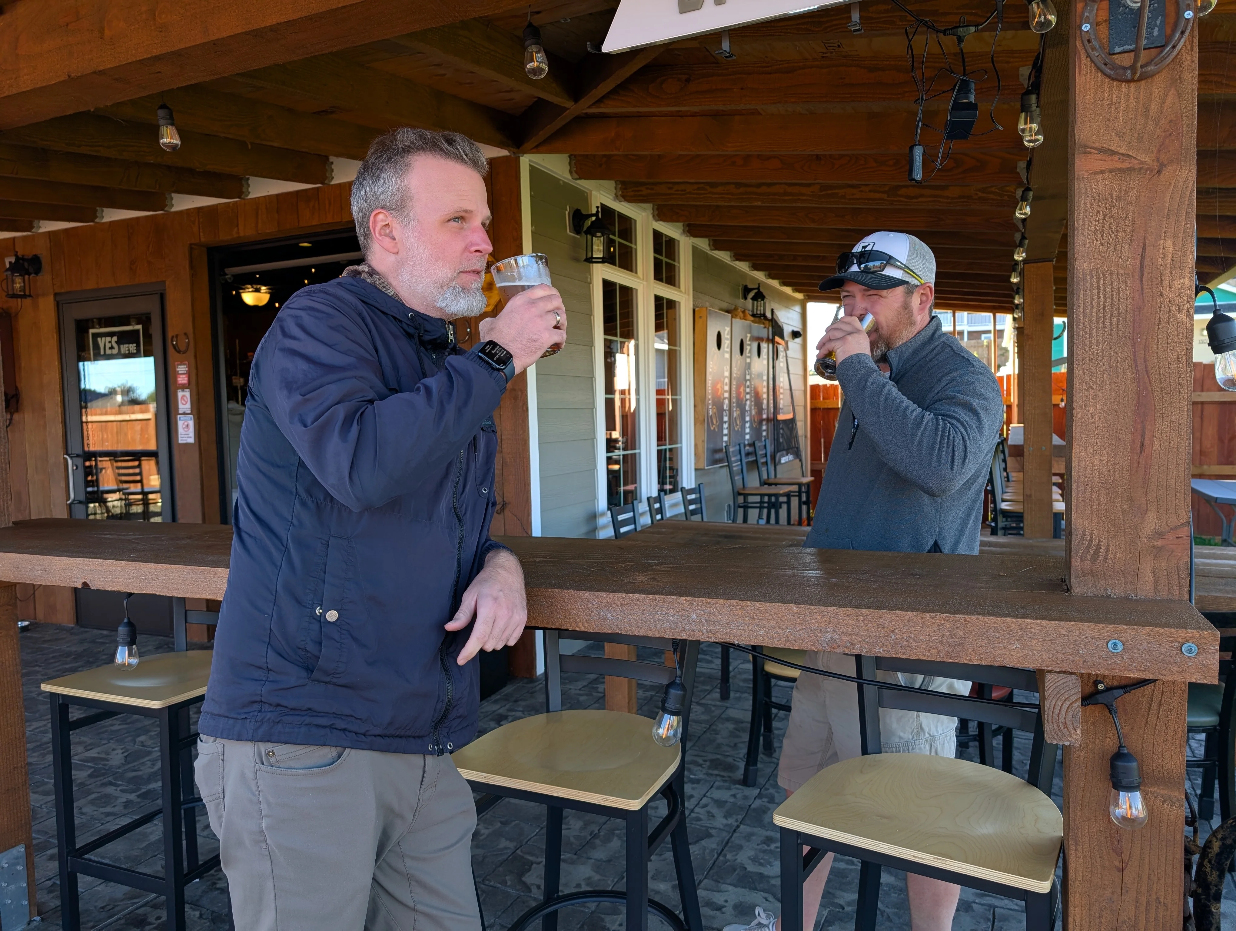 Two men enjoying craft beers at a rustic bar