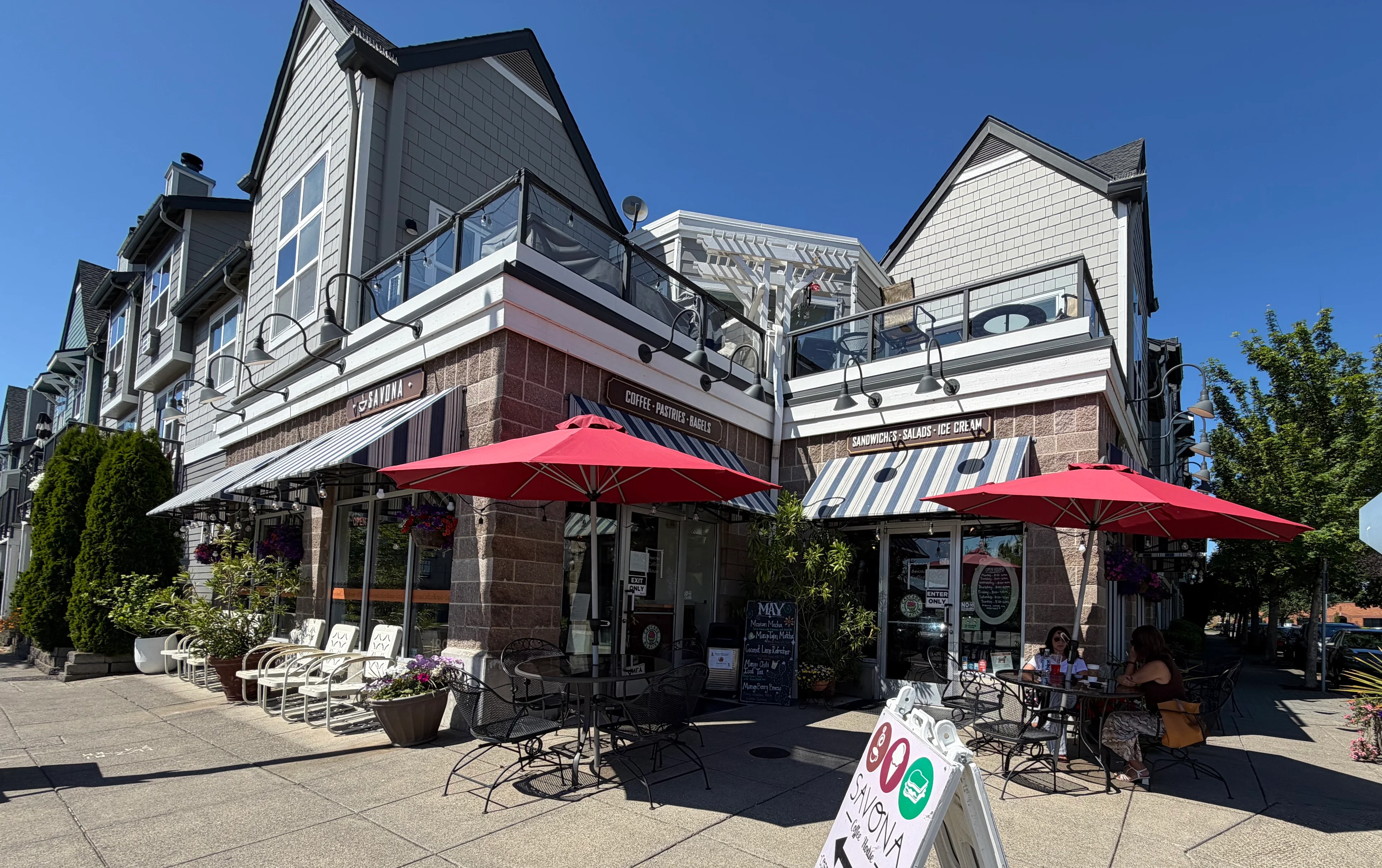Charming café exterior with red umbrellas and outdoor seating